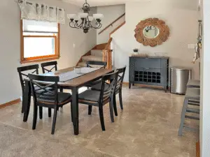 Dining area, adjacent to the kitchen, has additional barstool seating